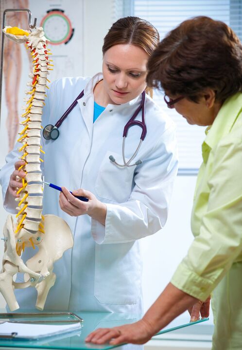 zdravnik pokaže osteohondrozo hrbtenice na maketi
